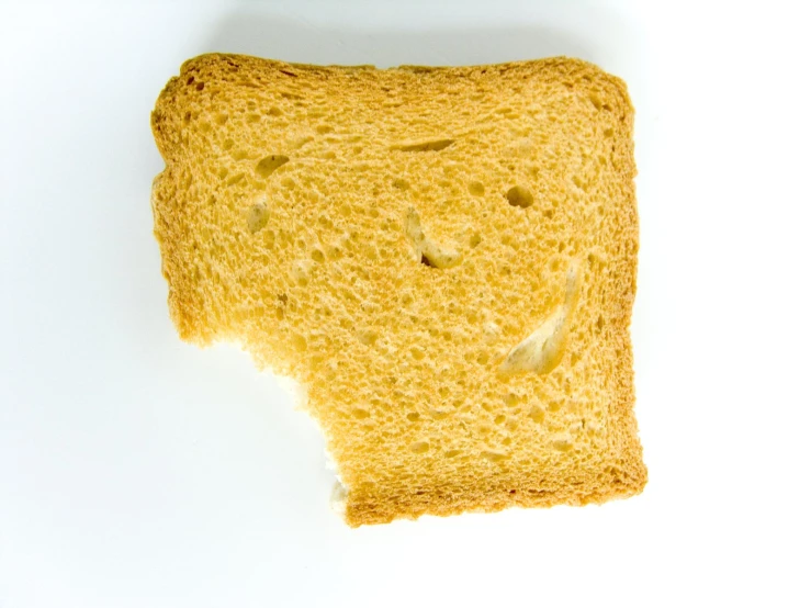 a piece of toast with holes and a smiley face on top