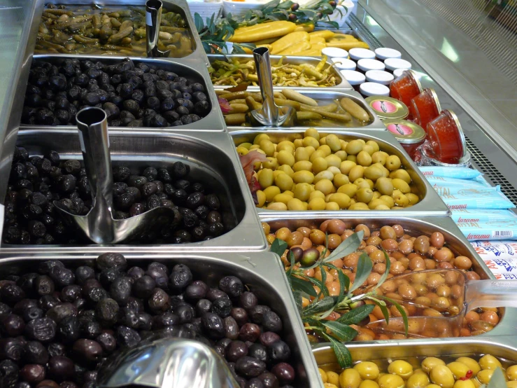 assorted fruit are kept in metal bins in a display case