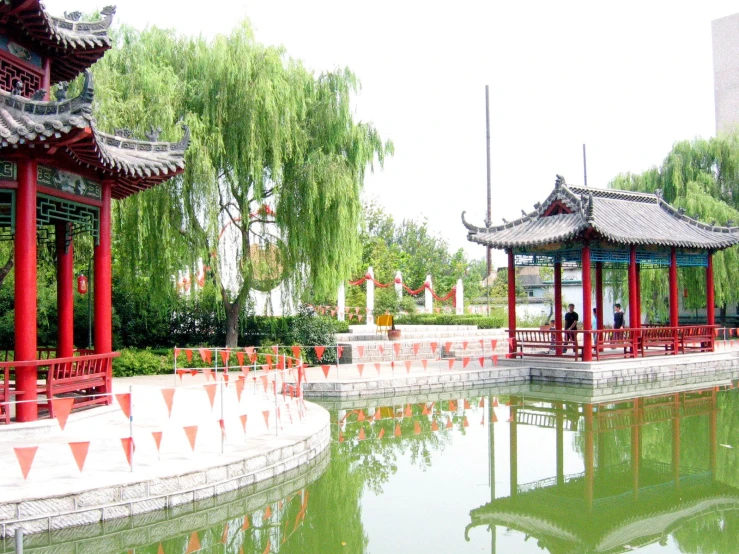 red benches on either side of an asian pond