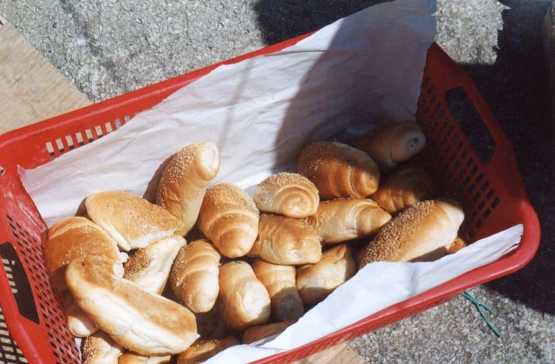 a red basket filled with croissants on top of a floor