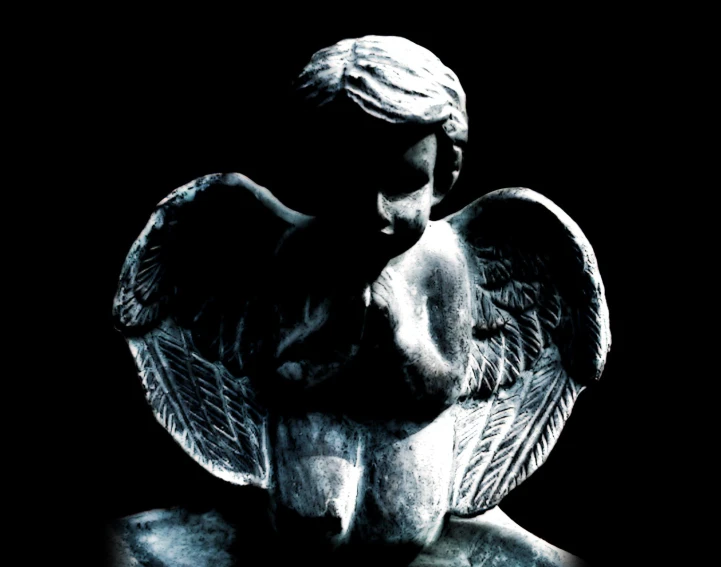 an angel sculpture standing with his wings spread out