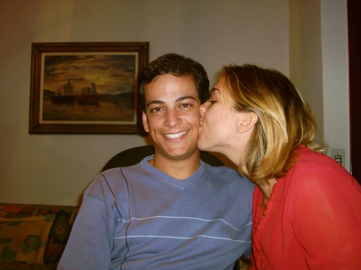 two people sharing a kiss and laughing at the same time