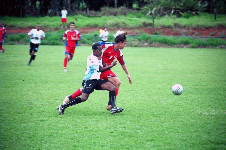 soccer players on a field fighting for the ball