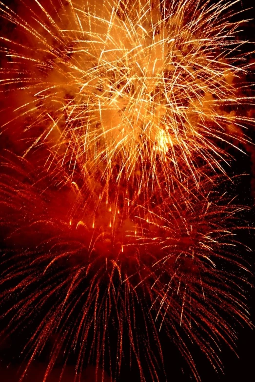 bright fireworks in the night sky with red and yellow lights