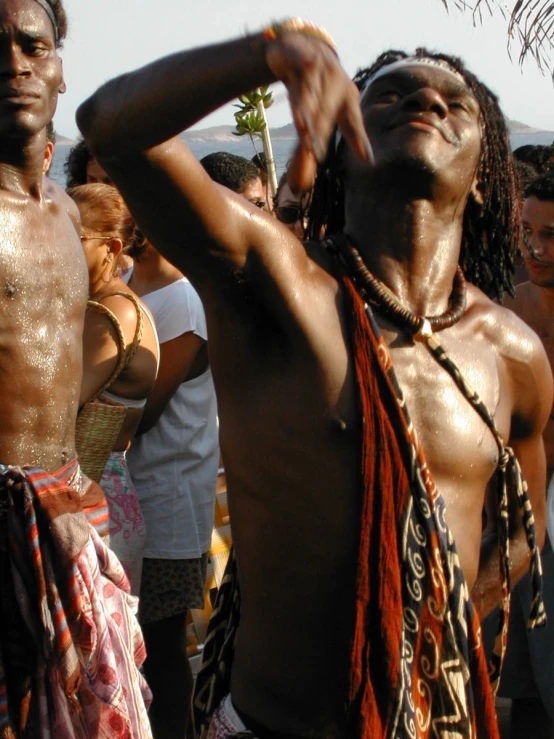 a man with very large hairy bodies is standing in the street while a crowd looks on