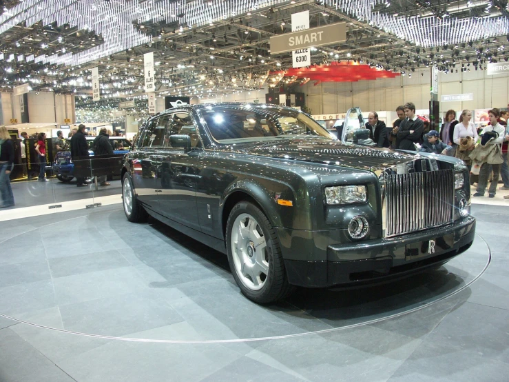 a black rolls royce is shown at a car show