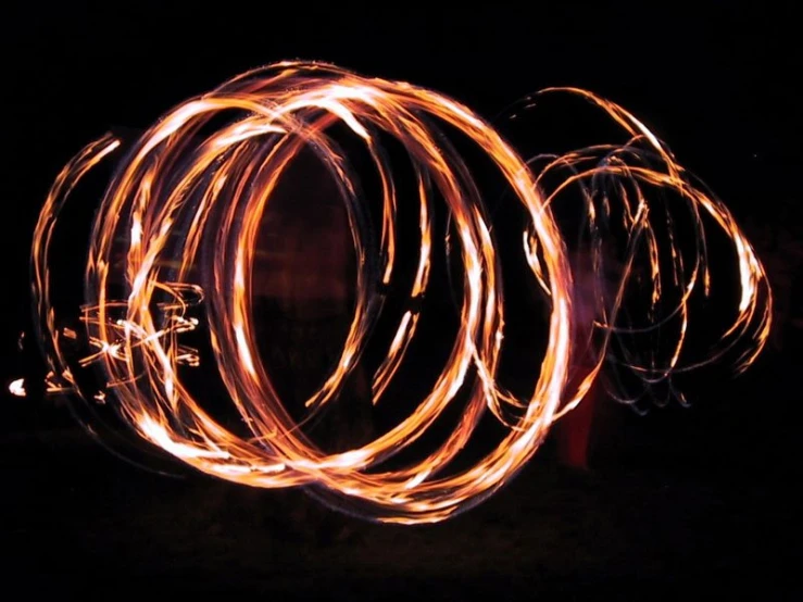 three circular fire hulaps lit up at night