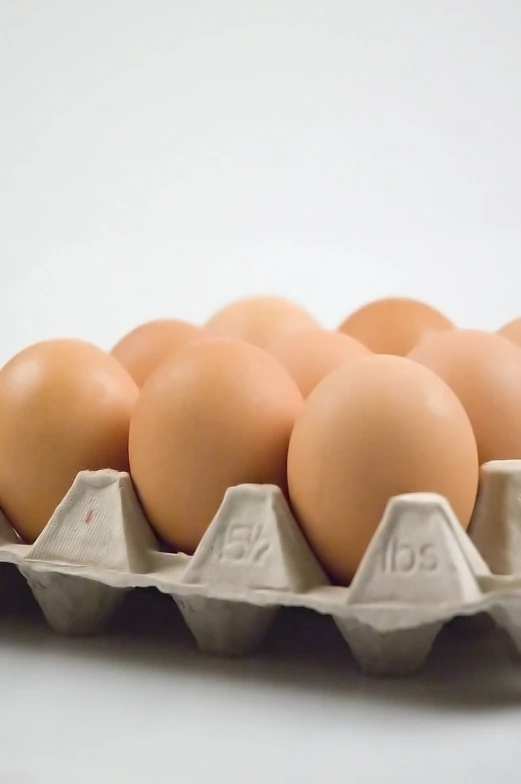 several brown eggs in cartons on a white surface