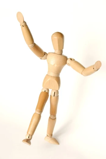 a wooden doll pointing a leg in front of the camera