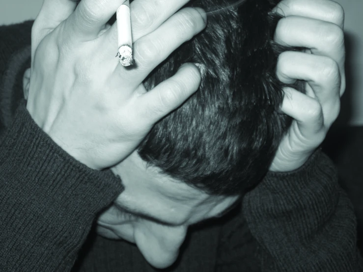 a man smoking and holding his head back