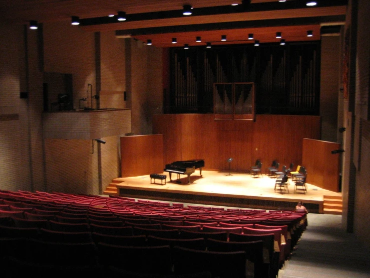an auditorium area with chairs, piano and sound equipment