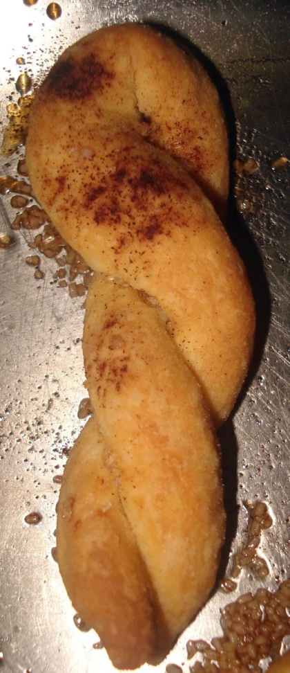 three fried pastry items sitting on top of a wok