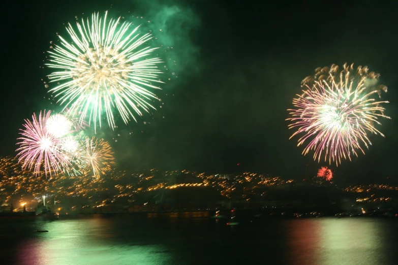 some fireworks and lights in the sky above water