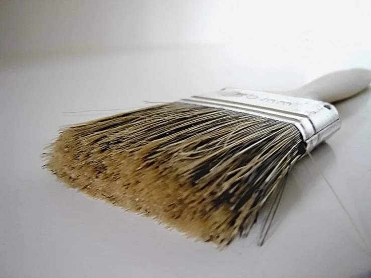 a white brush with yellow bristles on it