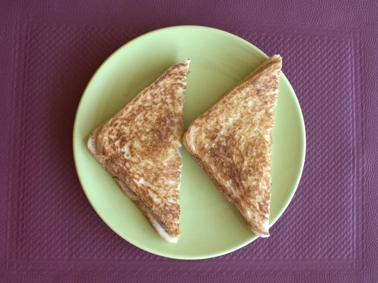 two triangles of bread on a green plate