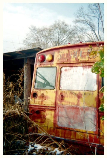 an old, rusty school bus that is sitting in the weeds