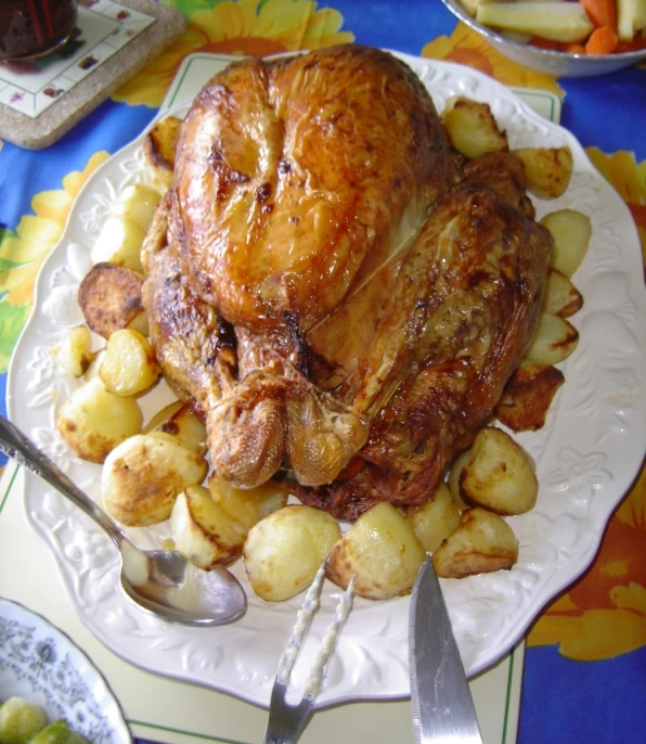 a dinner plate with roast and potatoes, a knife and fork