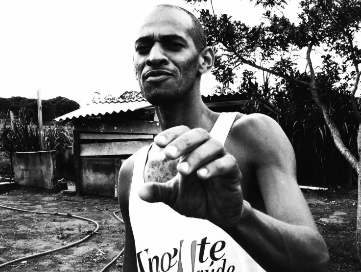 man in white top holding an object by the camera