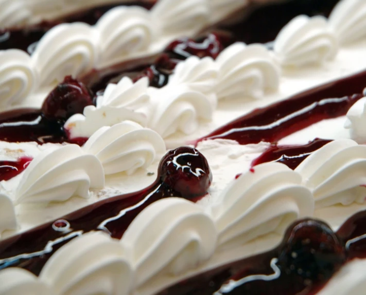 a close up s of a homemade cheesecake covered in whipped cream and cherries