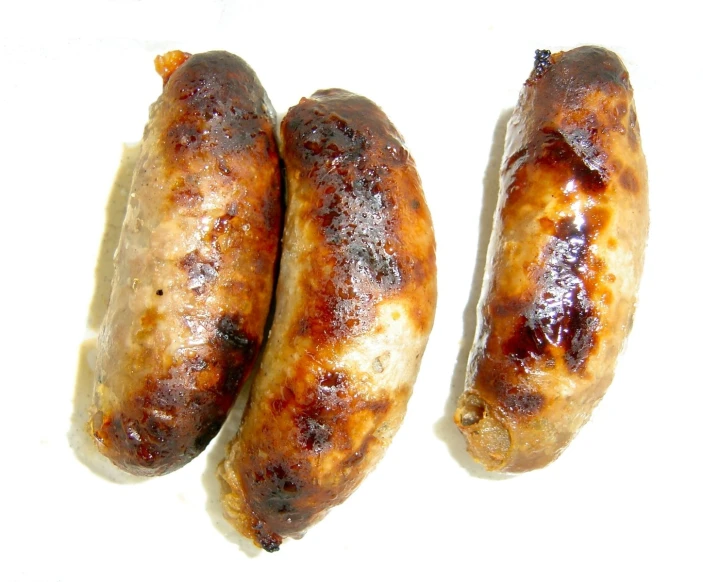 two sausages on a plate sitting next to each other