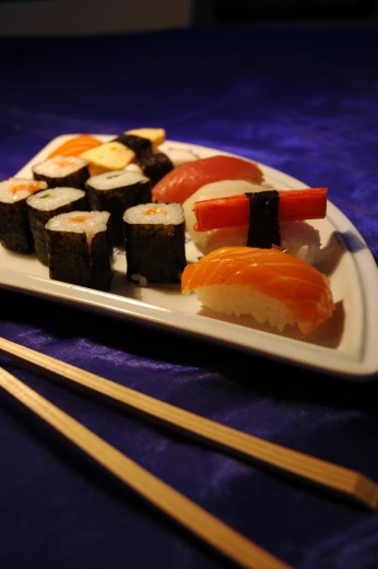 this is sushi and chopsticks on a plate