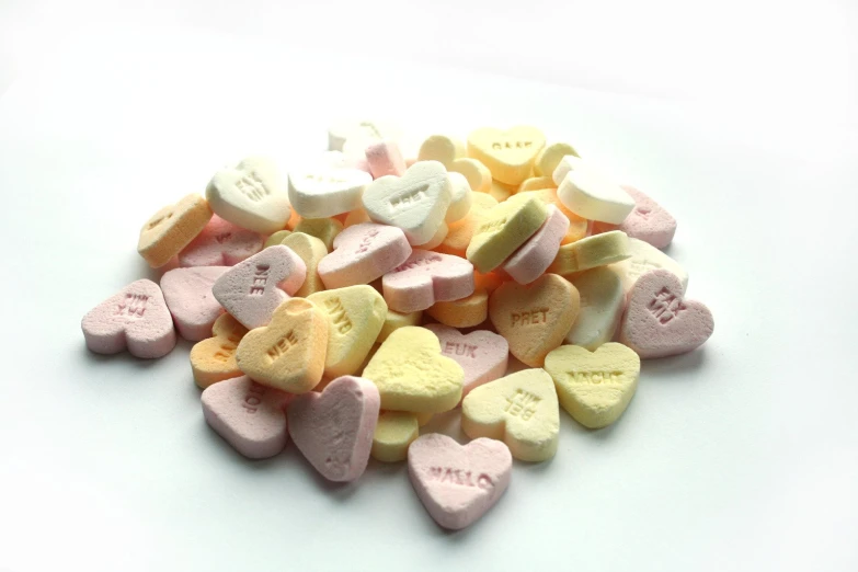 several heart shaped candy candy pieces on a white surface