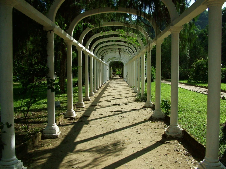 a long white corridor leads to the grass and trees