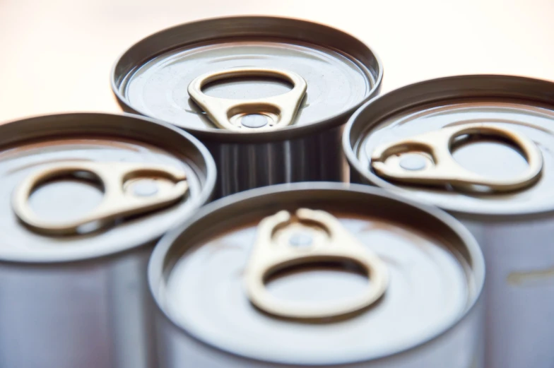 four open cans with the top part opened and showing metal parts