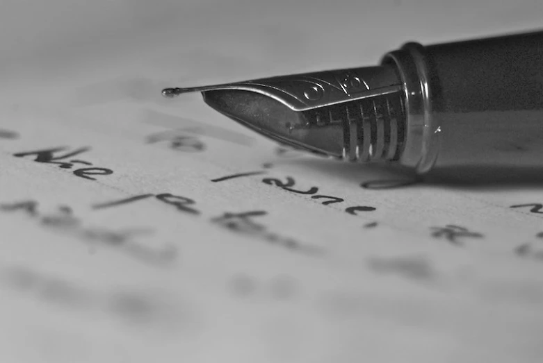 a pen writing on paper with writing