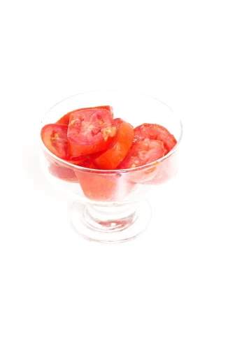 tomatoes in a clear bowl sitting on the table