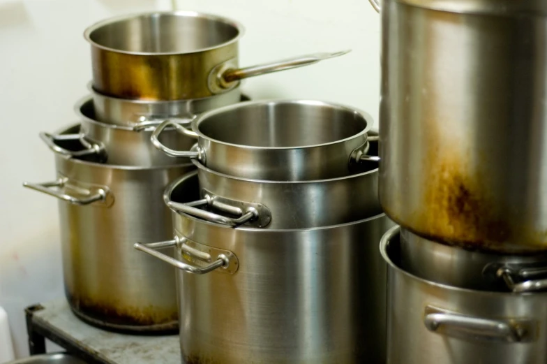 several pots and pans lined up on a counter