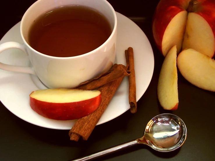 a cup of tea and apples on a table