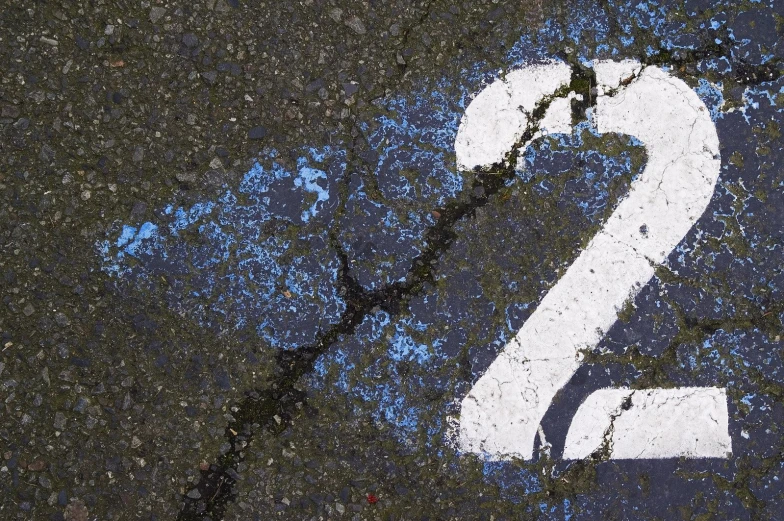 the number 2 painted on a road in front of a black background