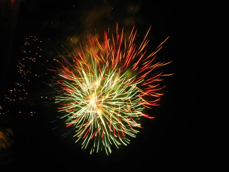 a fireworks in the night sky, lit up by colorful lights