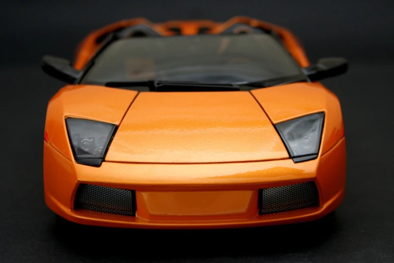 an orange model car is on display