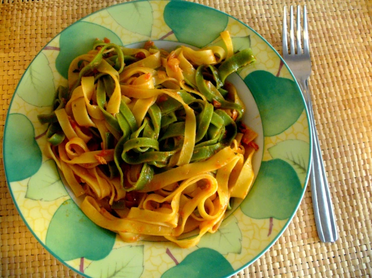 a plate with a pasta dish with green beans and cheese