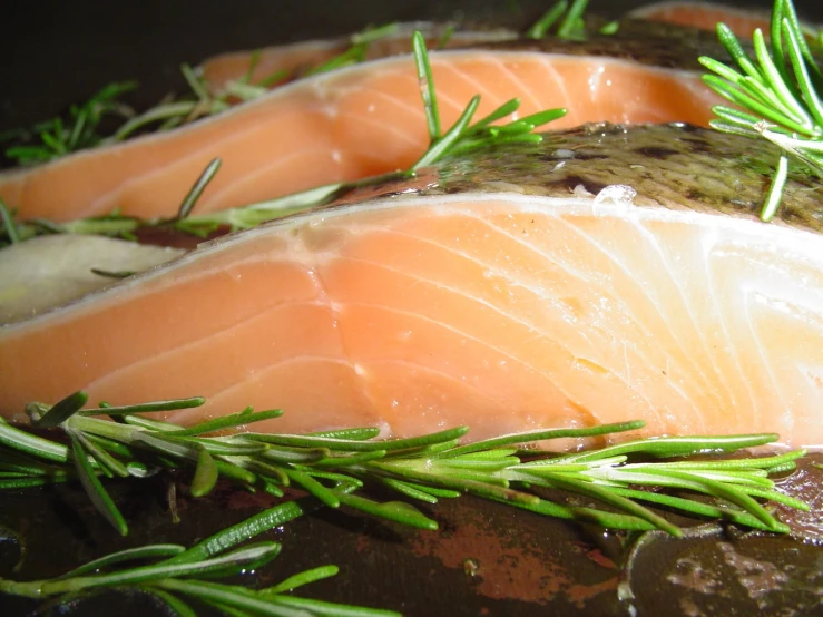 a large amount of fish fillets sitting on top of a pan