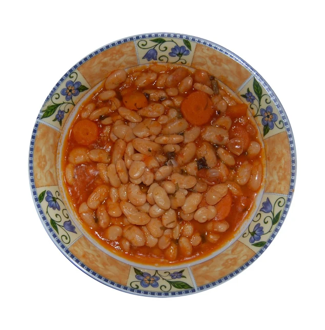 a bowl of beans with carrots and onions on a patterned plate