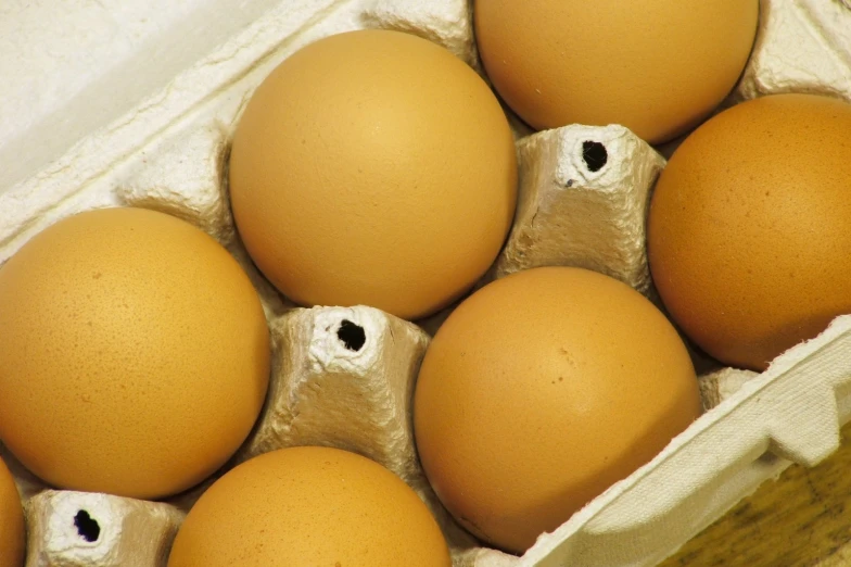 a carton filled with eggs with an egg sticker on one of them