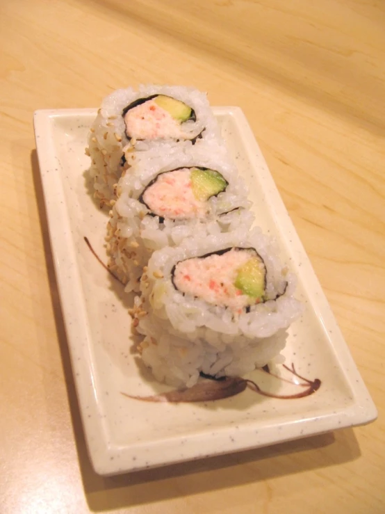 a couple of different sushi with green and yellow garnish