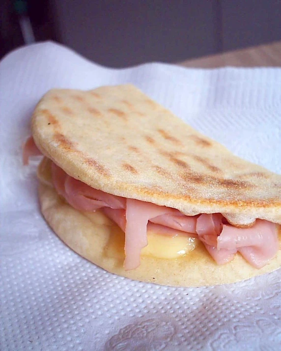 a white paper towel holding a sandwich on top of it