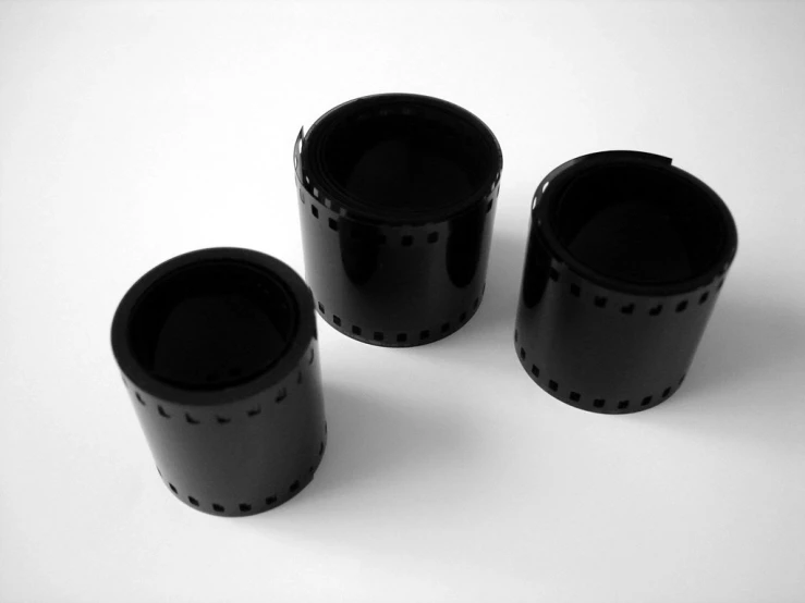 a set of three black drinking glasses are shown in a white background