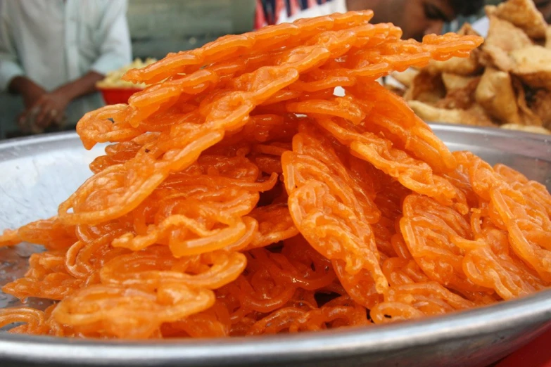 orange rings are stacked in a bowl on the table