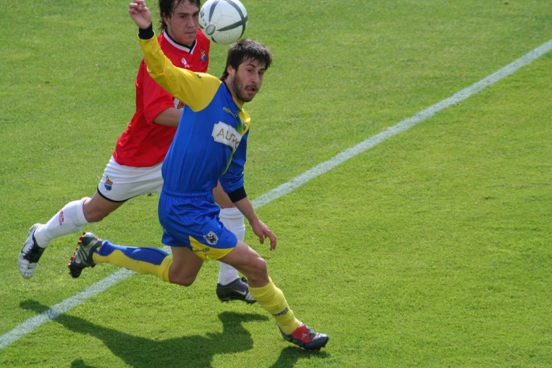 two soccer players are playing the ball during a match