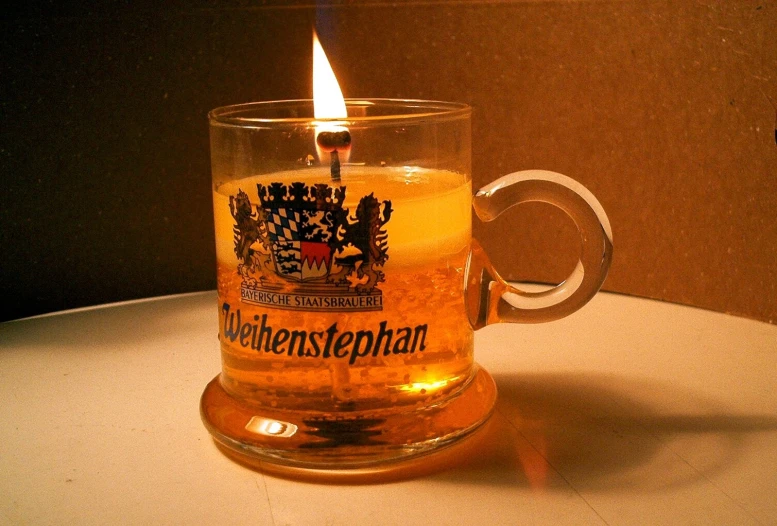 a large candle sitting in a coffee mug