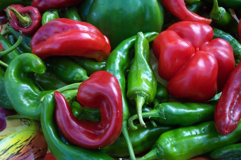many different types of peppers piled on each other