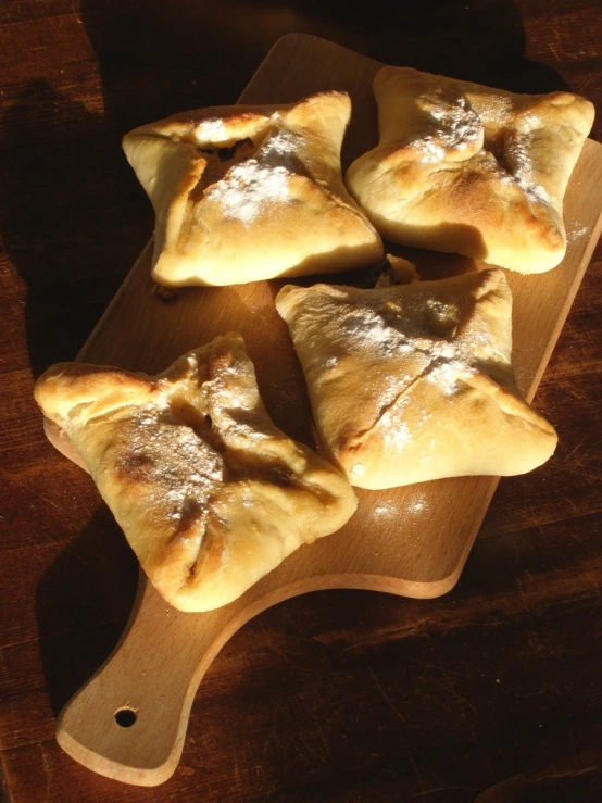 small pastries sitting on top of a  board