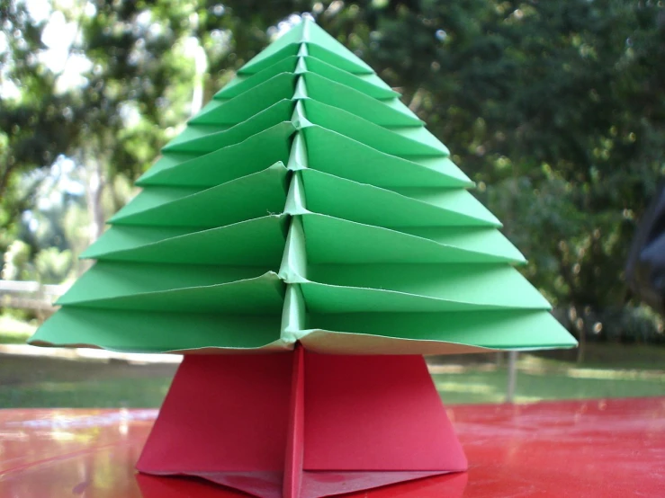 paper christmas tree sitting on top of red table