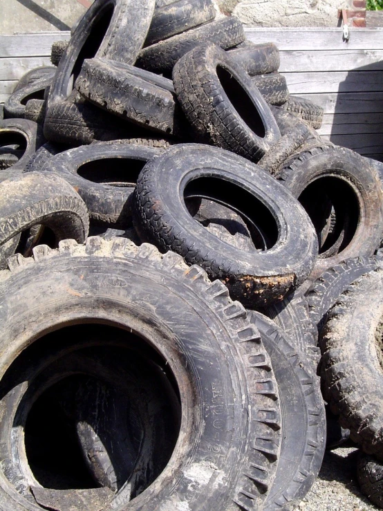 a pile of old tires piled up on a wooden ledge