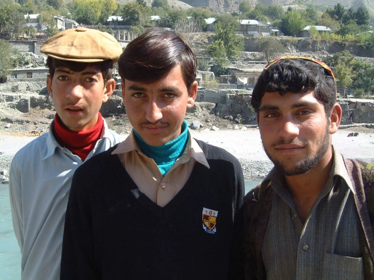 three boys posing for a po with their neck scarves